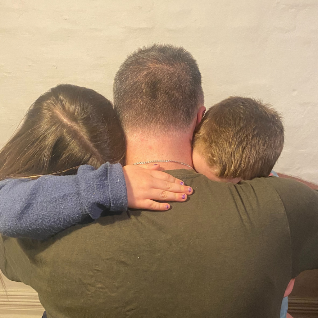 Inmate holds his two children visiting him in prison